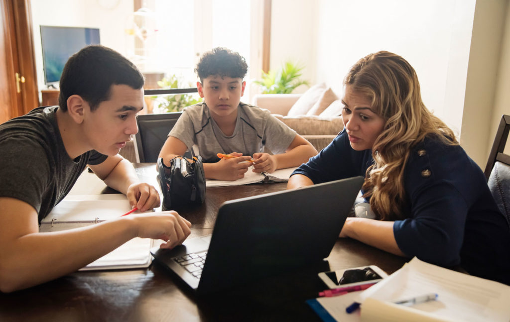 Three persons looking on laptop for homeschooling