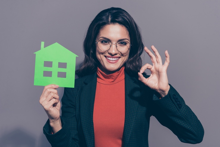 Listing agent holding a cutout of a house